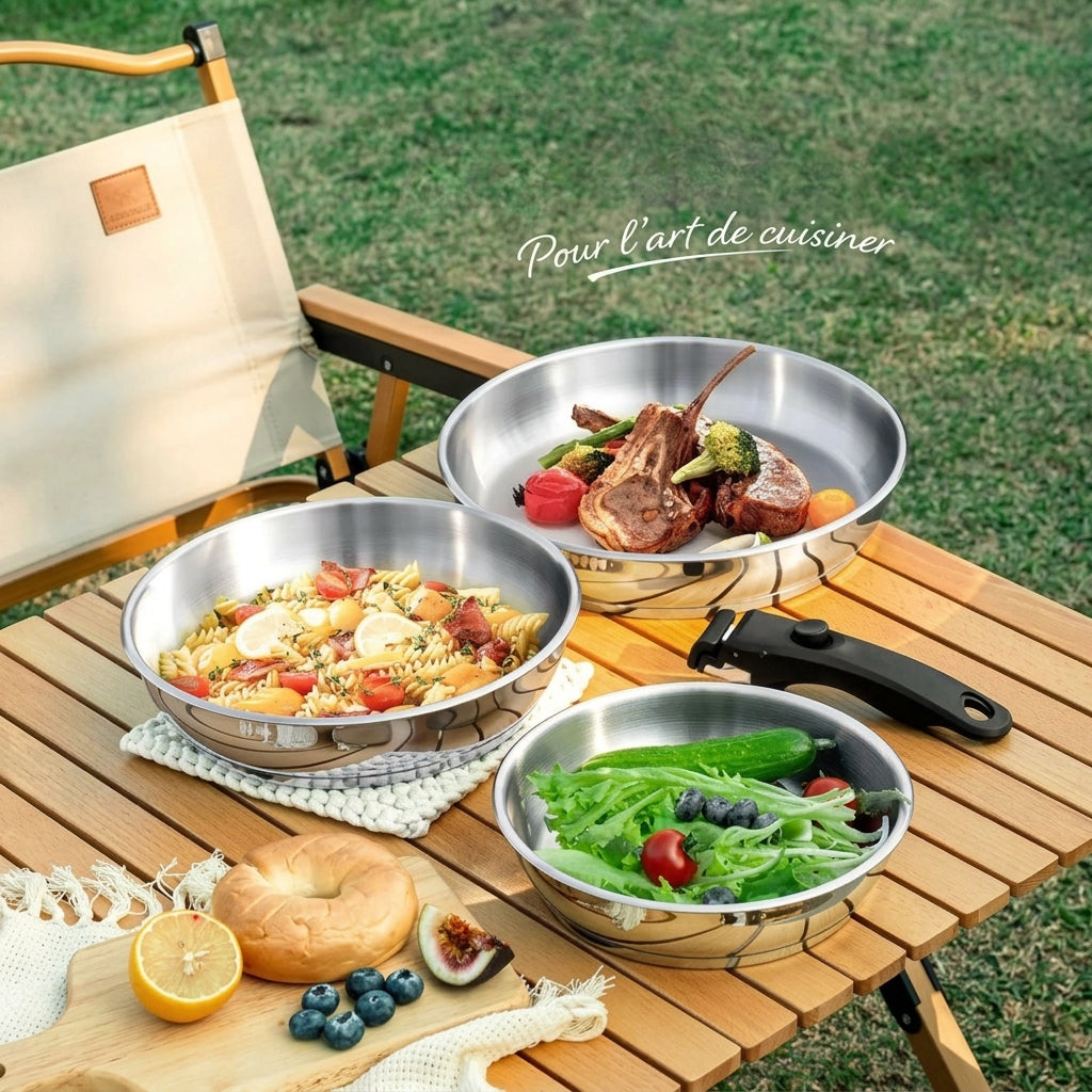 Poêles inox à manche amovible utilisées en extérieur sur une table de camping