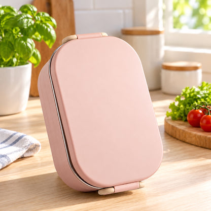Boîte bento inox rose posée debout dans une cuisine lumineuse