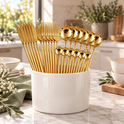 Couverts dorés rangés dans un pot en céramique blanche